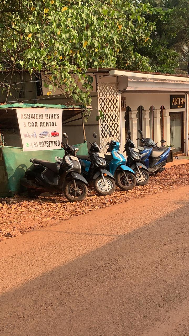 Scooters lined up outside the ASHVEM Rides bike and car rental point in Ashvem, North Goa